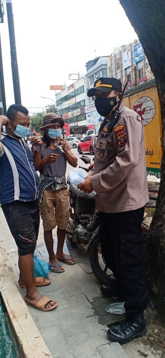 Cegah Penularan Covid-19, Kanit Binmas Polsek Medan Baru Bagikan Masker ke Warga