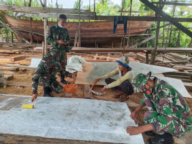 Prajurit Kipan B Yonif 645/Gty Bantu Warga Perbaiki Perahu