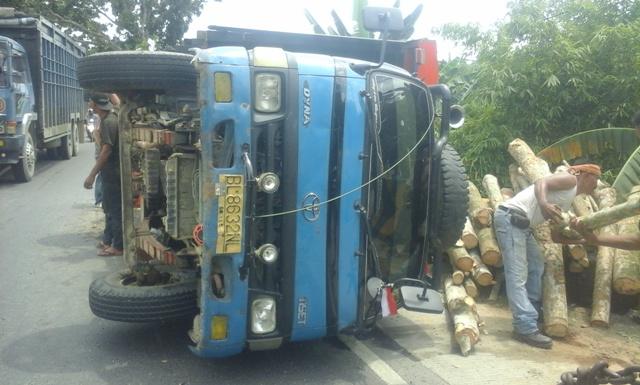 Ban Pecah, Truk Bermuatan Kayu Balok Terbalik di Langkat