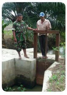 Babinsa Koramil 15/Bandar Pulau Lakukan Pembersihan Saluran Irigasi